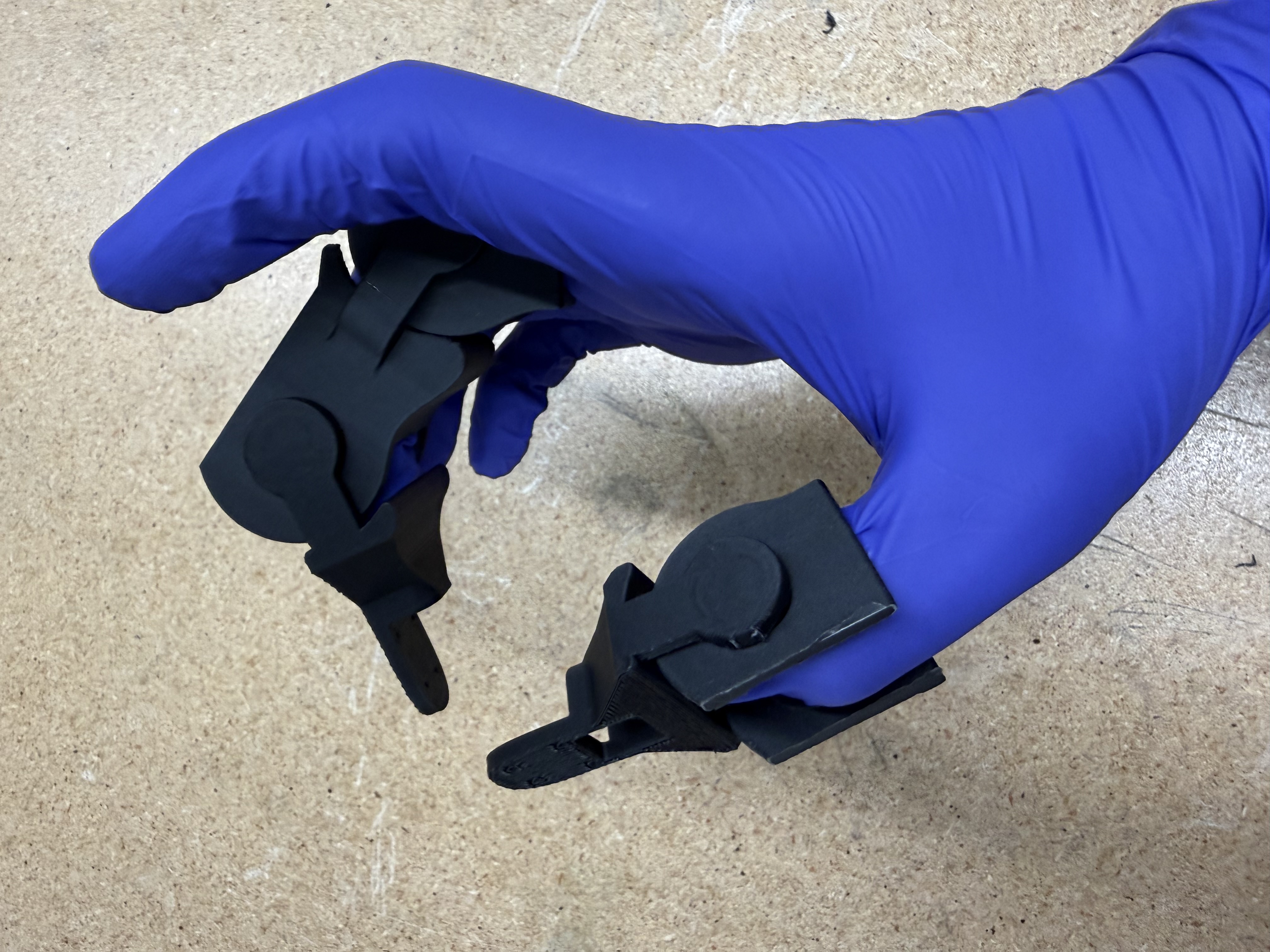 Human-operated puppet gripper held by a gloved hand