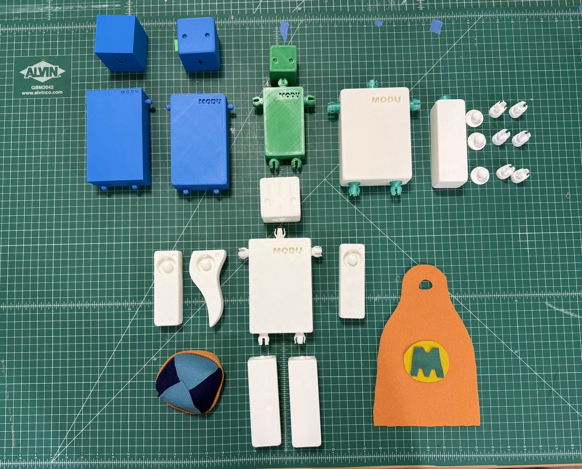 MODU modular prototype components and printed iterations arranged on a cutting mat