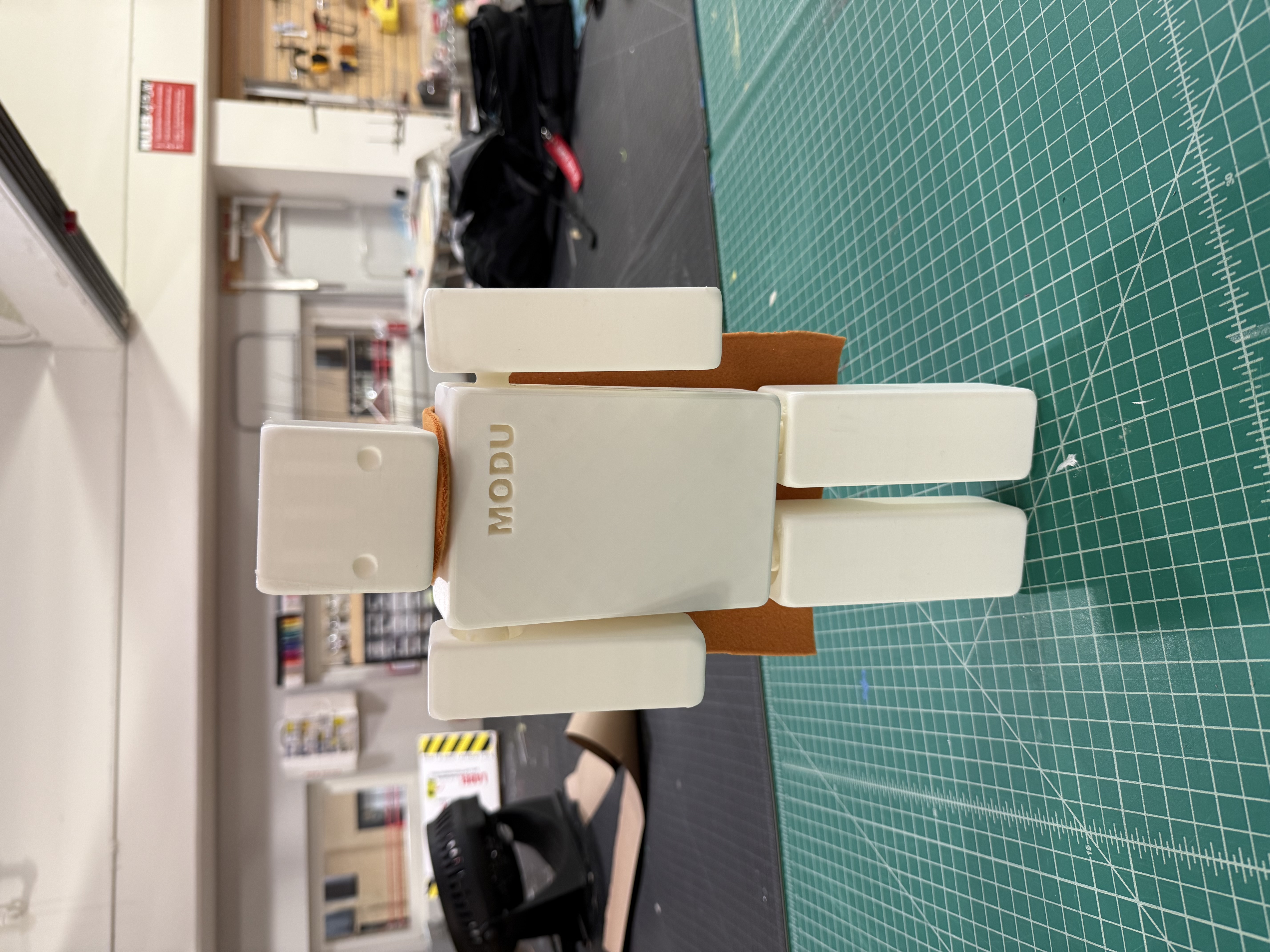 Final assembled white MODU prototype with an orange fabric cape